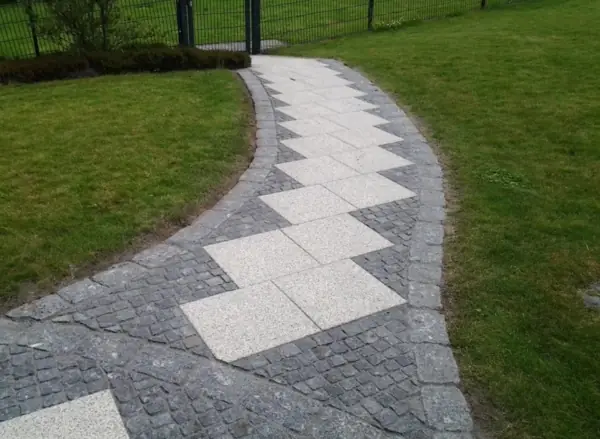 Derselbe Weg nach der Reinigung, Zickzackmuster und dunkler Kopfsteinrand klar erkennbar