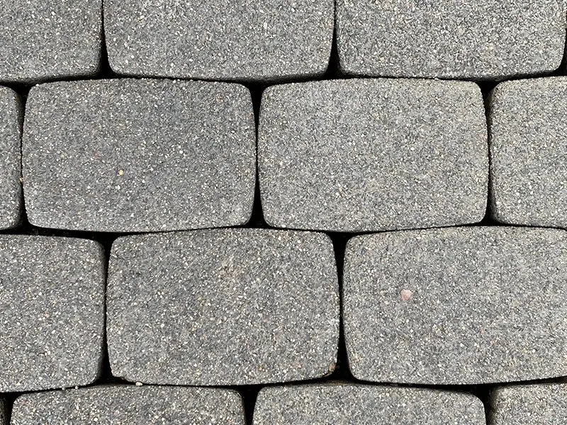 Betonpflaster mit ausgewaschenen, tief leeren Fugen zwischen den Steinen